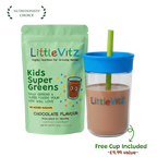 LittleVitz Kids Super Greens chocolate flavour powder pouch shown next to a clear plastic cup with a bright blue lid and straw, filled with the prepared drink. The packaging features a light green background with colorful text and graphics.
